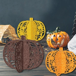 Three glitter hollowed-out pumpkin tabletop ornaments in gold, brown, and orange