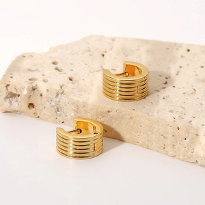 Minimalist 18K gold plated ribbed stainless steel hoop earrings on stone background