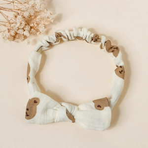 Detail of soft cream cotton baby headband with bow and cute brown bear prints