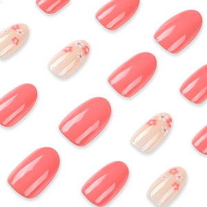 Pink and white gradient press-on nails with floral patterns and glossy round oval finish