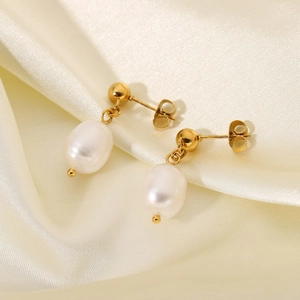 Elegant gold-tone drop earrings with white teardrop pearls on silk background