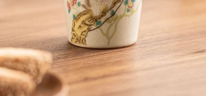 Close-up of hand-painted floral patterns and Ru ware ice-crack glaze on ceramic tea cup