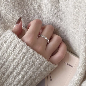 Close-up of minimalist S925 sterling silver ring featuring linked 3D heart shapes on a finger