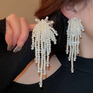Detailed view of elegant long pearl tassel earrings on a model for a stylish look