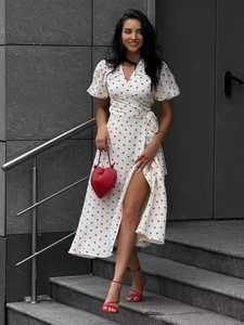 Detail of white wrap dress with red heart print, puff sleeves and high side slit design