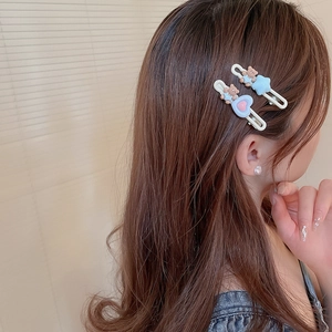 Gros plan de mignonnes barrettes ours bleues portées par un mannequin au look doux