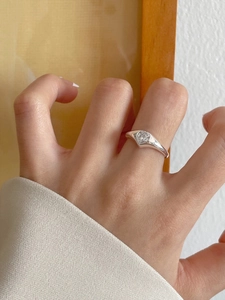 Close-up of a minimalist 925 sterling silver ring with a sparkling heart-shaped zircon