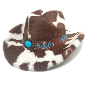 Close-up of cow print cowboy hat featuring blue floral embroidery and turquoise stone