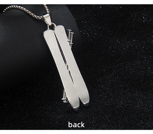 Back view of silver stainless steel snowboard pendant necklace on textured background