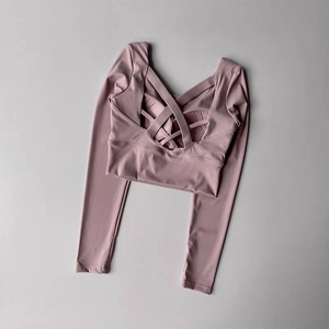 Vue détaillée du crop top manches longues rose poudré avec dos croisé sportif
