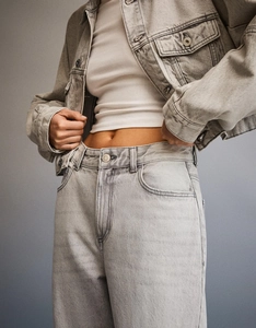 Detail of high-waisted washed gray denim jeans and jacket with metallic buttons