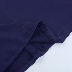 Detailed close-up of double-needle hem stitching on a dark blue knitted bodycon dress