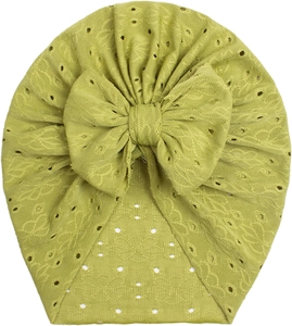 Detail of baby mustard turban hat with eyelet knit texture and large bow decoration