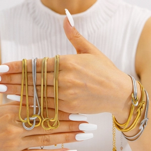 Set collana e bracciale a catena serpente bicolore indossato da una modella elegante
