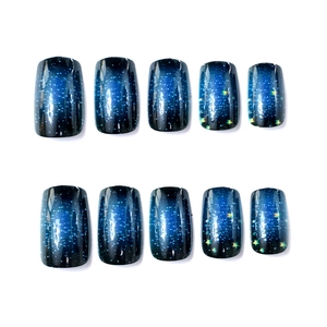 Detail of 10-piece press-on nails with blue starry night gradient and yellow stars