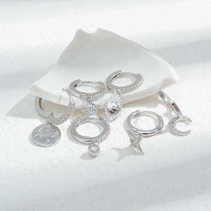 Silver celestial earring set with zircon star moon and pearl charms on white background