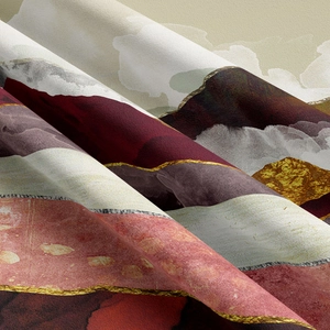 Close-up of abstract mountain tapestry with gold details and soft burgundy fabric texture