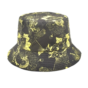 Detailed view of black fisherman hat featuring yellow fan patterns and stitching on the brim