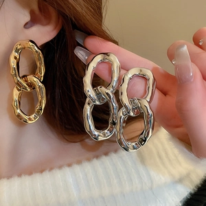 Détails de boucles d'oreilles oversize en métal martelé or et argent avec texture