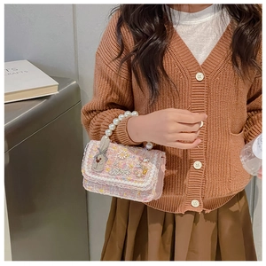 Detail of pink tweed girl's handbag with daisy embroidery and elegant pearl handle