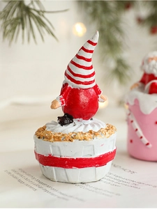Close-up of a festive Christmas gnome resin figurine on a cupcake base with pine needle decor