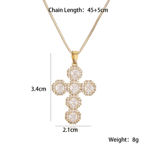 Macro shot of gold cross pendant with cubic zirconia stones and product dimensions