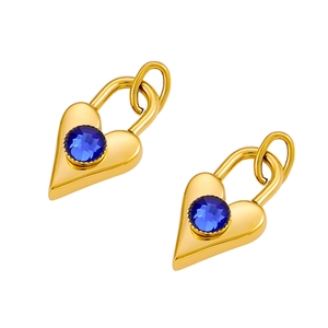 Close-up of golden heart padlock earrings with a blue gemstone on white background