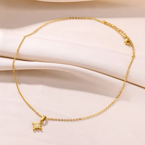 Detailed macro view of gold star pendant necklace with zircon stone on silk fabric