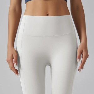 Detailopname van de witte yoga broek met hoge taille, zijzakken en elastische stof