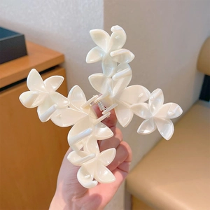 Detail of pearlescent white lily flower hair claw clip with sturdy metal spring mechanism