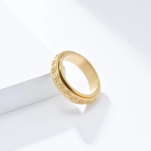 Minimalist gold-plated stainless steel spinner ring with delicate daisy flower relief pattern