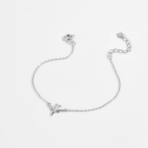Macro shot of S925 sterling silver airplane pendant on a delicate link chain bracelet