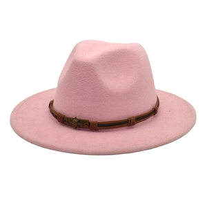 Detailed shot of pink wool fedora with brown leather band and bronze skull ornament