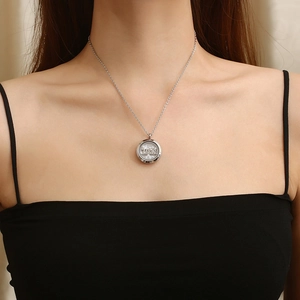 Close-up of a silver glass floating locket necklace featuring a Mae letter charm on model
