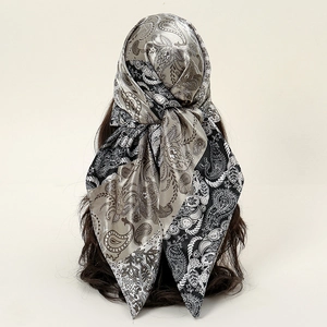 Foulard en satin cachemire gris et noir noué en bandeau avec une texture soyeuse