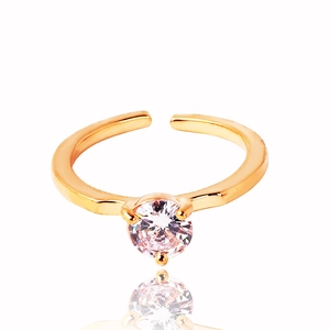 Macro detail of gold plated ring with round zircon and four-prong setting