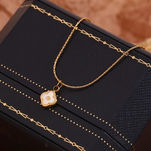 Close-up of 18K gold floral necklace with shell inlay on a jewelry box display