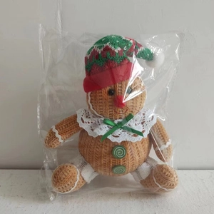 Detailed close-up of a knitted gingerbread man doll with a festive hat and lace collar