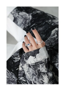 Detail of silver S925 rings with irregular texture and blue zircon on a hand