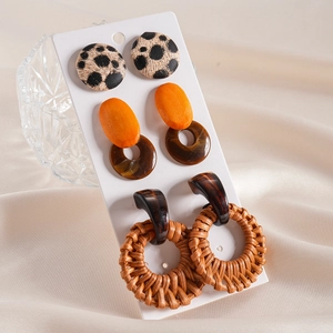 Close-up of three pairs of bohemian earrings with leopard fabric, wood and resin textures