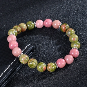 Macro detail of natural sunstone and rose quartz beads on a fertility bracelet