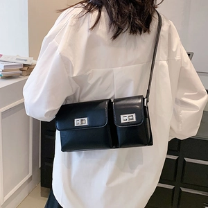 Back view of model wearing a black double-pocket baguette bag with silver hardware locks