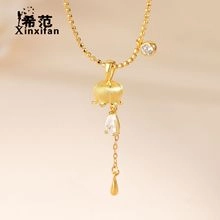 Macro detail of lily of the valley gold pendant with a teardrop crystal and chain
