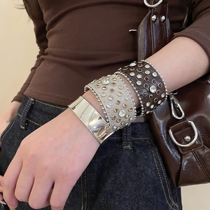 Gros plan de bracelets punk superposés avec strass et manchette en métal sur un mannequin