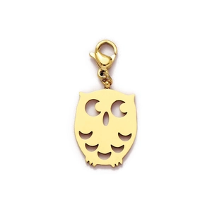 Detailed close-up of a gold owl charm pendant with hollow textures and lobster clasp