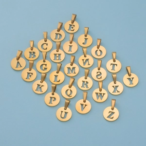 Macro view of 26 gold hollow alphabet charms in round shape with mirror finish