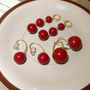 Detailed macro of red resin bead earrings with gold plating and sparkling rhinestones