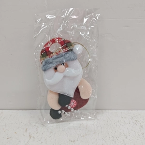 Nahaufnahme von Weihnachtsmann-Filzanhänger mit Perlenbeinen in Plastikverpackung
