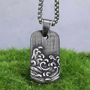 Gros plan d'un pendentif en acier vintage avec relief détaillé de vagues de mer