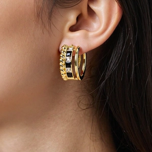 Close-up of three-tier gold-plated hoop earrings with micro-set cubic zirconia on ear